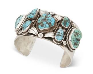 43
A Southwest sterling silver and turquoise cuff bracelet
Mid-20th century
Unmarked
A chunky sterling silver cuff set with seven nugget turquoise stones with color gradation, applied silver accents, and with stamped terminals
7.25" total inner C x 1.5" H, with a 1.5" gap
127.7 grams gross
Estimate: $400 - $600
