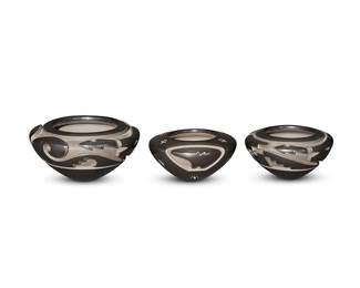20
Effie & Orville Garcia (b. 1954, Santa Clara Pueblo & b. 20th century, Acoma Pueblo)
A group of blackware pottery, late 20th/21st century
Each with incised signature to underside: Effie Orville Garcia / SCP
Comprising three tapered wide jars, the largest with deeply incised curvilinear Avanyu "water serpent" motif to shoulder (2.5" H x 5" Dia.), as well as a smaller jar with incised geometric-style stepped Avanyu motif (2.125" H x 4" Dia.), and a smooth tapered small jar with an incised "heartline" bear motif to one side, and scattered small etched sgraffito "bear paw" motifs overall (2.125" H x 4" Dia.)
3 pieces
Estimate: $1,000 - $1,500