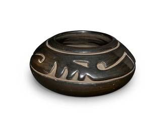 8
Margaret Tafoya (1904-2001, Santa Clara Pueblo)
A blackware pottery jar, mid/late 20th century
With incised signature to underside: Margaret Tafoya / Santa Clara Pue.
The stone-polished shouldered jar with a deeply incised curvilinear motif to shoulder
4" H x 9" Dia.
Estimate: $1,000 - $1,500