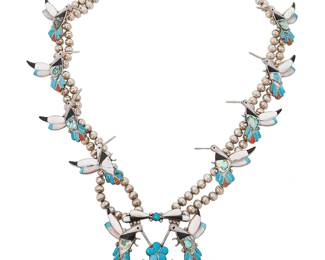 314
A Southwest silver and inlay hummingbird "squash blossom" necklace
Late 20th century
Unmarked
With an elaborate sterling silver hummingbird "naja" and eight hummingbird "blossoms" in stone and shell inlay including turquoise, coral, mother of pearl, white shell, and jet, all set to a double strand of silver beads
27.5" L x 3.25" H
149.9 grams gross
Estimate: $600 - $900