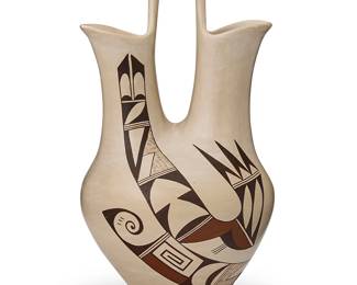 183
Joy "Frog Woman" Navasie (1919-2012, Hopi-Tewa)
A Hopi/Tewa polychrome white slip pottery wedding vase, mid/late 20th century
Signed with the artist's frog cypher to underside
The stone-polished elongated vase featuring flared spouts joined by an arched handle, with curvilinear and geometric swirling bird motifs to each side of body
13.75" H x 6.75" Dia.
Estimate: $300 - $500
