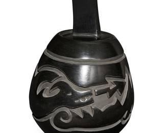 15
Jason Ebelacker (b. 1980, Santa Clara Pueblo)
A Santa Clara blackware lidded pottery jar, late 20th/21st century
With incised signature to underside: J L Ebelacker / Santa Clara Pueblo
A tall jar with deeply carved Avanyu water serpent banded motif, and with rectangular lid
2 pieces
Overall: 10" H x 5" Dia.
Estimate: $600 - $800