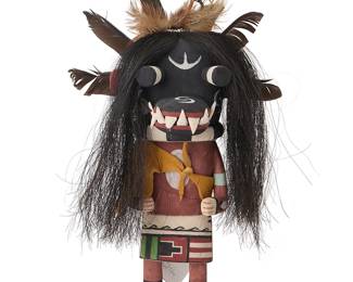 197
Mark Taho
(b. 1972, Hopi-Third Mesa/Diné)
A Hopi Pueblo Tasaveyo Ogre katsina
Polychrome painted cottonwood, feathers, horsehair, leather
With large black mask, featuring a snout with teeth, long hair, suede sash, and elaborate feather headdress to mask verso, signed to underside: Taho
13" H x 7.5" W x 6.5" D
Estimate: $300 - $500
