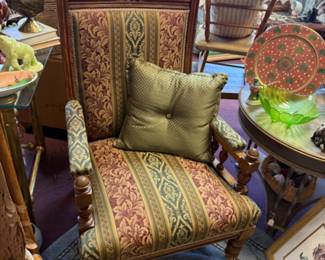 Antique upholstered armchair with carved wooden frame upholgerd with rich patterned fabric 