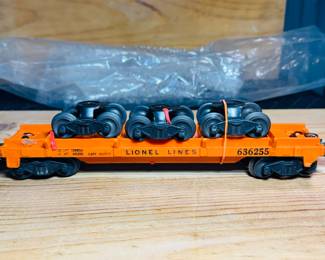 post war Lionel flat car with three rail trucks load