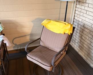 patio swivel chair, outdoor deck furniture, cushioned porch chair, metal patio chair, floor lamp with shade, indoor outdoor seating.
