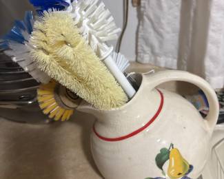 Antique pitcher holding misc kitchen brushes