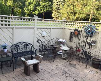 Lots of wrought iron and stone garden seating and decor 