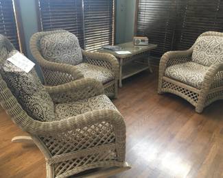 Fine set of wicker furniture, two chairs, rocker and coffee table. Cotton covered cushions.