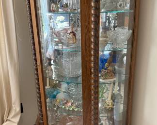 This beautiful, rounded glass curio cabinet provides a wonderful space for any prized possessions or collectibles.