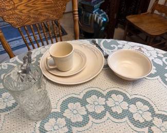 This is a place setting of the dinnerware we are selling. There is the Corelle dish, small plate, bowl and cup, and silverware and glass. There are full sets of everything, although we have some mixes and matches with a very similar pattern for the Corelle to expand the number of people who can be served. The Corelle pattern here is the blue lily pattern.