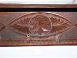 Close up of carving on black walnut shelf.