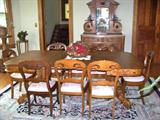 Elegant walnut dining room table with burled walnut sides. Has 5 leaves. Eight walnut chairs with matching upholstered seats.