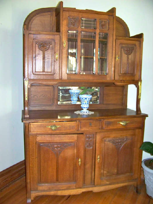 European oak sideboard with beautiful carving and grape pulls.  Beveled glass in doors