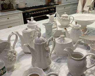 A collection of all white tea pots and cake plates
