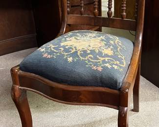 Intricately carved side chair with embroidered seat