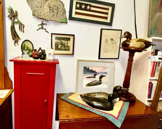 Red modern cabinet, antique drop leaf table, wall art, Ducks Unlimited prints, decoys, etc.