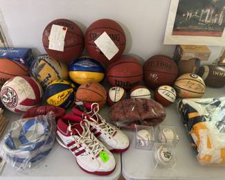 living room west wall on table. signed basketballs, signed bucks shoes with ticket stub from game, signed baseballs