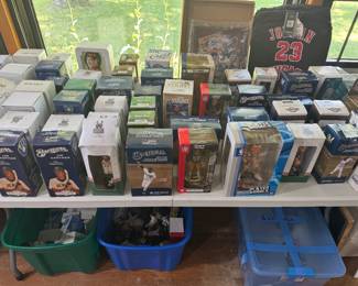 living room west wall on table and under table dozens of bobble heads