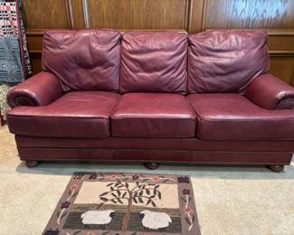 Burgundy/Red Leather 3 cushion sofa.  In good condition. Rolled arms, tufted back.  Great napping!