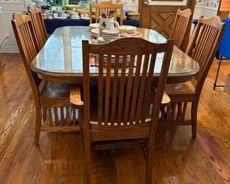 Amish Made Oak Table and 2 arm  chairs and 6 dining chairs.  Leaves store under table top.  Locking system.  Glass Top custom made