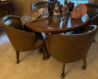 This is an unusal round table with 2 gate legs and leaves for extension.  4 Club Chairs on casters 