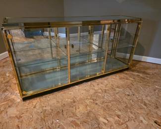 Gold and glass lighted display cabinet. 