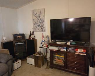 Kenmore sound system (tuner, disc player, cassette), with speakers and phonograph. 55" Roku style smart-TV. Media console 48"W with 3 drawers, glass door storage. Miscellaneous gnome decor and collectible Monopoly board games. 