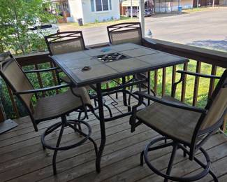 Outdoor pub-height table with 4 sling, swivel chairs. Kept on covered patio. 