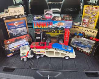 Assorted collectible cars and figurines. See's Candy metal truck, Wings of Texaco plane, Hot Wheels VW Bus, Unocal 76 Tanker truck, RC Jeep - new  and unused, Burago Viper,  Vintage small scale Radio Flyer, Pepsi Can Car Shooter, Metal semi and car hauler with 2 plastic cars)