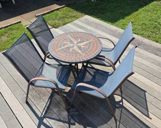 Small outdoor mosaic table with 4  blue outdoor sling chairs. 