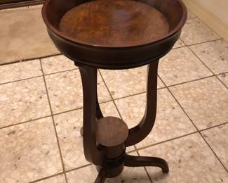 Baker wood plant stand with burled wood detail.