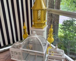 collection of bird cages, all painted yellow or white