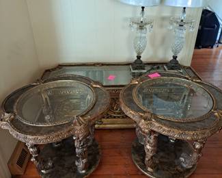 2 antique French ornate table with coffee table. Gold tone embelishments with including decorative carvings and detailed boarder around table tops. 2 vintage cut glass Hollywood Regency style table lamps.