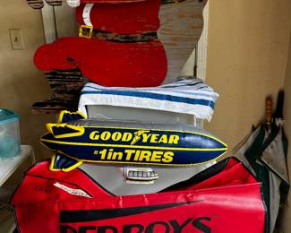 Inflatable Good Year blimp, PepBoys fender cover, wooden Santa 