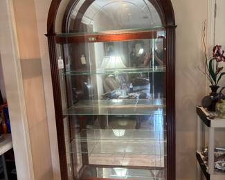 Beautiful arched curio cabinet.  Mirrored bottom, lighted top.  $375.