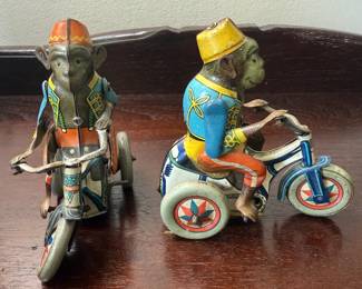 Vintage-style wind-up toy featuring monkey riding a tricycle