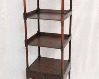 Antique 4-tier wooden whatnot shelving unit with bun finials, one drawer beneath lowest shelf, and on metal caster wheels