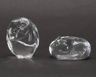 A marvelously tactile "The Owl and the Pussycat" combination of American art glass sculptures from Steuben, a pair of art glass pieces that are cooling works of art to fit in the palm of your hand. The comfortably curled up Cat was designed by Lloyd Atkins in 1983 and the wise little Owl designed by Lloyd Atkins in 1980. Both pieces are hand signed Steuben on the base. Cat model 5520VAA is 2 1/2 inches L x 3 inches H; Owl model 5516 is 2 1/2 inches tall.