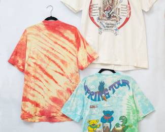 Reverse view of the Vintage Grateful Dead t-shirts: A Grateful Dead 'Blues for Allah' tie-dye t-shirt, a Grateful Dead skull 'What a Long Strange Trip It's Been' t-shirt, and a Grateful Dead Spring Tour Liquid Blue tie-dye t-shirt