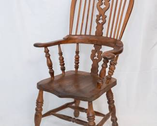 The second of three antique mid 19th century English broad arm Windsor chairs