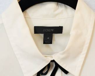 Closeup of the J Crew cream color blouse with black ribbon bow accents, size 4