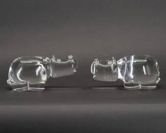 Two vintage Steuben Glass hippo fgurines - whimsical art glass!A pair of hippopotamus figurines in crystal clear glass by Steuben. Each has a Steuben signature engraved on the base. Hippo shape No. 8280, size 6-1/2 inches L x 2-1/2 inches W x 3 inches H.