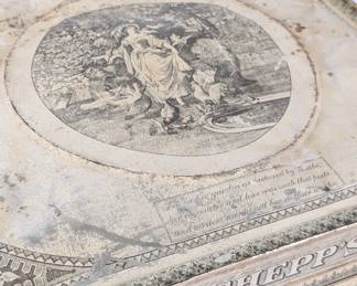 Closeup of an early antique Schepps advertising cake box, tin construction with genre scenes throughout and single door opening to partially shelved interior, c1910. Decorated on front with a lithograph of Wilhelm von Kaulbach's painting depicting Goethe's "Sorrows of Werther." Both sides are decorated with lithographs depicting Ludwig Lindenschmit's painting "Friedrich Schiller at Weimar" along with a vignette by Kaulbach of "Dorothea (and the Emigrants)."