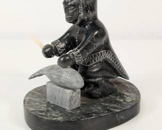 Vintage stone sculpture of Inuit eskimo cleaning fish