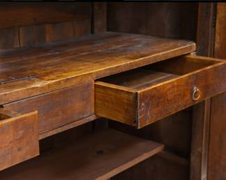 Closeup of the interior of the French 19th Century carved wooden two door cupboard or armoire with internal shelving and two drawers