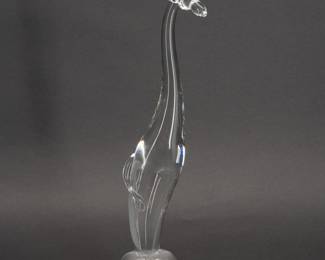 A large Steuben clear leaded glass giraffe figurine, shape No. 8119, of elongated form on a domed base. Designed by Lloyd D. Atkins and introduced in 1963. Signed “Steuben" to the base. Measures 15 inches H.