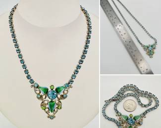 A gorgeous sky blue rhinestone link necklace with center pendant of enameled leaves and large blue central rhinestone