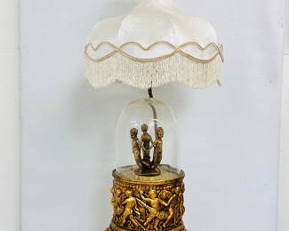 A Hollywood Regency era/style table lamp with cherubs decoration and fabric shade