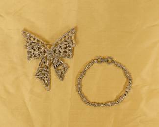 Reverse of the vintage Vendome green and clear rhinestone ribbon bow brooch, and a vintage green and clear rhinestone bracelet